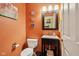 Compact powder room showcasing a granite vanity, decorative mirror, and artistic wall decor at 9311 Windrift Way, Zionsville, IN 46077