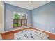Blue-walled room with hardwood floors, a floral rug, and natural light at 9311 Windrift Way, Zionsville, IN 46077