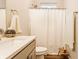 Neutral bathroom featuring a shower with white curtain, a single sink, and bronze fixtures at 965 Astor Ln, Carmel, IN 46032