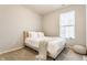 Cozy bedroom features a comfortable bed with white linens, a grey throw, and a natural light from the window at 965 Astor Ln, Carmel, IN 46032