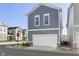Two-story home featuring gray siding, a white garage door, and manicured landscaping at 965 Astor Ln, Carmel, IN 46032