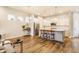 Open-concept design with a modern kitchen, stylish bar seating, stainless steel appliances, and wood flooring at 965 Astor Ln, Carmel, IN 46032