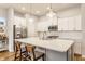 Bright kitchen featuring white cabinets, stainless steel appliances, a subway tile backsplash, and a quartz island at 965 Astor Ln, Carmel, IN 46032