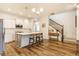 Open-concept kitchen and staircase with white cabinets, stainless steel appliances, and a large island at 965 Astor Ln, Carmel, IN 46032