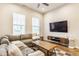 Comfortable living room with a large sectional sofa, modern entertainment center, and bright windows, perfect for relaxation at 965 Astor Ln, Carmel, IN 46032