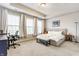 Spacious main bedroom with a tray ceiling, large windows and a cozy seating area at 965 Astor Ln, Carmel, IN 46032