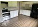 Functional kitchen with white cabinets, stainless steel appliances, and durable vinyl plank flooring at 1002 Brookside Ln, Plainfield, IN 46168