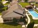 Backyard view of a house featuring a swimming pool, lounge chairs, and a covered outdoor kitchen at 1026 Summer Way Dr, Shelbyville, IN 46176