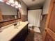 Well-lit bathroom with a vanity, toilet, tub, shower with stone-look flooring, and tiled walls at 1026 Summer Way Dr, Shelbyville, IN 46176
