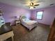 Cozy bedroom with a soft lavender walls, plush carpet, a ceiling fan, and a comfortable bed at 1026 Summer Way Dr, Shelbyville, IN 46176