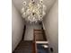 View of the stairs with carpet and wooden banister under an ornate chandelier at 1026 Summer Way Dr, Shelbyville, IN 46176