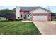 Charming brick home with a well-manicured lawn and inviting turquoise front door at 1026 Summer Way Dr, Shelbyville, IN 46176