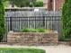 Landscaped raised planter near a black metal fence offers backyard privacy at 1026 Summer Way Dr, Shelbyville, IN 46176