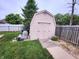 View of a shed surrounded by lush greenery and a privacy fence, offering storage and functionality in the backyard at 1026 Summer Way Dr, Shelbyville, IN 46176