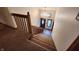 Carpeted staircase leading to the entry way with an elegant chandelier at 1026 Summer Way Dr, Shelbyville, IN 46176