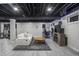 Finished basement with tile flooring, exposed ceiling, and a seating area with a TV at 107 W Columbine Ln, Westfield, IN 46074