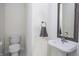 Clean half bath with a pedestal sink, toilet, and a framed mirror, offering functionality at 107 W Columbine Ln, Westfield, IN 46074