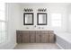 Bright bathroom featuring double vanity, framed mirrors, and a large soaking tub by the window at 107 W Columbine Ln, Westfield, IN 46074