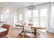 Cozy dining area with a wooden table, white chairs, and large windows with sheer curtains at 107 W Columbine Ln, Westfield, IN 46074