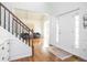 Bright foyer featuring hardwood floors, a staircase with white balusters, and an open view into a living area at 107 W Columbine Ln, Westfield, IN 46074