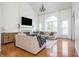 Open-concept living room with a fireplace, hardwood floors, soaring ceilings and large arched window at 107 W Columbine Ln, Westfield, IN 46074
