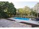 Backyard view of a sparkling in-ground swimming pool, framed by a well-manicured lawn and mature trees at 107 W Columbine Ln, Westfield, IN 46074