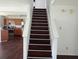 Staircase connecting open kitchen and living space with dark floors at 10795 Albertson Dr, Indianapolis, IN 46231