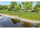 Spacious backyard featuring a well-maintained lawn, mature trees, and a scenic pond with natural rock borders at 10988 Eaton Ct, Fishers, IN 46038