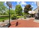 Well-maintained backyard features a brick patio with dining set and lush green lawn perfect for relaxing or play at 10988 Eaton Ct, Fishers, IN 46038