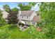 Aerial view of a lush backyard featuring a brick patio with a dining set, mature trees, and scenic surroundings at 10988 Eaton Ct, Fishers, IN 46038