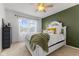 Inviting bedroom featuring a large window, stylish decor, and an olive accent wall at 10988 Eaton Ct, Fishers, IN 46038
