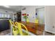 Inviting dining area showcases a rustic wood table with yellow chairs, complemented by an open-concept kitchen and living space at 10988 Eaton Ct, Fishers, IN 46038