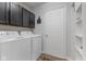 Functional laundry room with modern appliances, storage cabinets, and a neatly organized shelving unit at 10988 Eaton Ct, Fishers, IN 46038