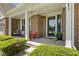 Inviting covered porch featuring chairs, manicured shrubs, brick pillars, and a secure storm door at 10988 Eaton Ct, Fishers, IN 46038