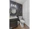 Chic powder room boasts floral wallpaper, wainscoting, a round mirror, and a contemporary vanity at 10988 Eaton Ct, Fishers, IN 46038