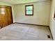 This bedroom features a neutral carpet, light walls, and a window at 1103 Canal St, Anderson, IN 46012