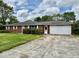 Charming brick ranch-style home featuring an attached garage, mature trees, and an expansive front yard at 1103 Canal St, Anderson, IN 46012