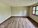 Empty living room with new wood-look flooring, fresh paint, and natural light from updated windows at 1103 Canal St, Anderson, IN 46012