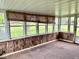 Enclosed porch featuring wood paneled walls and multiple windows at 1103 Canal St, Anderson, IN 46012