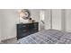 A bedroom featuring a black dresser, a silver mirror, and a bed with a patterned comforter for comfort at 11912 Vale St, Indianapolis, IN 46235