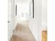 Bright hallway featuring tan carpet and white walls with artwork leading to a bathroom area at 1239 Thornwood Dr, Greenwood, IN 46143