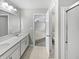 Bathroom featuring dual sinks with white cabinets and a view into the bedroom at 1276 Sanderling Dr, Greenwood, IN 46143