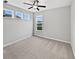 Bedroom features neutral carpet, a ceiling fan, and two windows with view of the water at 1276 Sanderling Dr, Greenwood, IN 46143