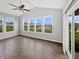 Bright sunroom features a vaulted ceiling, ceiling fan, and multiple large windows overlooking a lake at 1276 Sanderling Dr, Greenwood, IN 46143