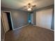 Spacious bedroom with neutral carpet, gray walls, ceiling fan, and closet space at 1280 Maple Ct, Martinsville, IN 46151