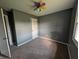 Well-lit bedroom featuring neutral carpet, gray walls, a fan, and ample closet space at 1280 Maple Ct, Martinsville, IN 46151