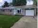 Charming brick home features a red roof, bay window, well-kept lawn, and an attached one car garage at 1280 Maple Ct, Martinsville, IN 46151