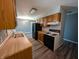 Efficient kitchen with wood cabinets, wood countertops, neutral walls and black appliances at 1280 Maple Ct, Martinsville, IN 46151
