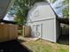 The shed is painted gray with white trim and double doors, plus a small window at 1280 Maple Ct, Martinsville, IN 46151