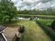 Backyard with a view of a pond with mature trees and a black metal fence at 14462 Brook Meadow Dr, McCordsville, IN 46055